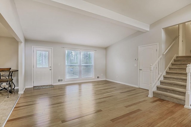 entrance foyer with vaulted ceiling with beams, light wood-style flooring, stairway, and baseboards