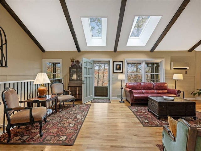 living room featuring light wood-type flooring, lofted ceiling with beams, and an AC wall unit