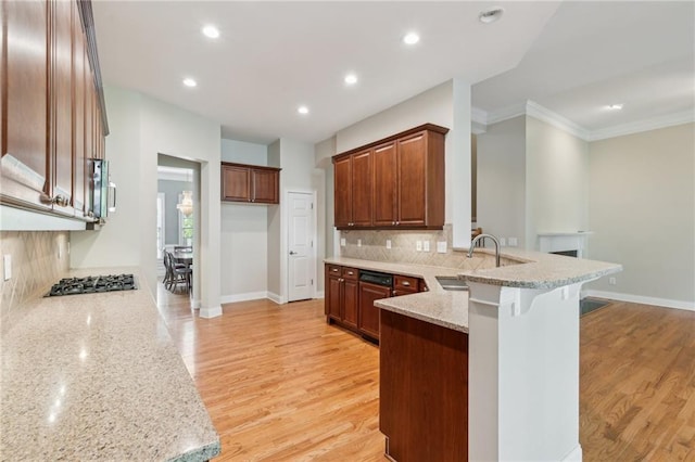 5882 Riverstone Cir Unit 15, Atlanta, GA 30339 - kitchen with a peninsula, a sink, stainless steel appliances, decorative backsplash, and crown molding