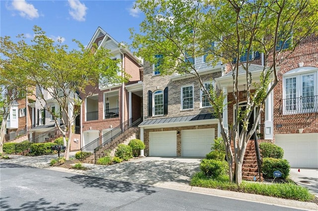 5882 Riverstone Cir Unit 15, Atlanta, GA 30339 - townhome / multi-family property with stairs, a garage, driveway, a standing seam roof, and brick siding