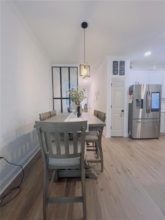 dining area featuring ornamental molding and light wood-type flooring