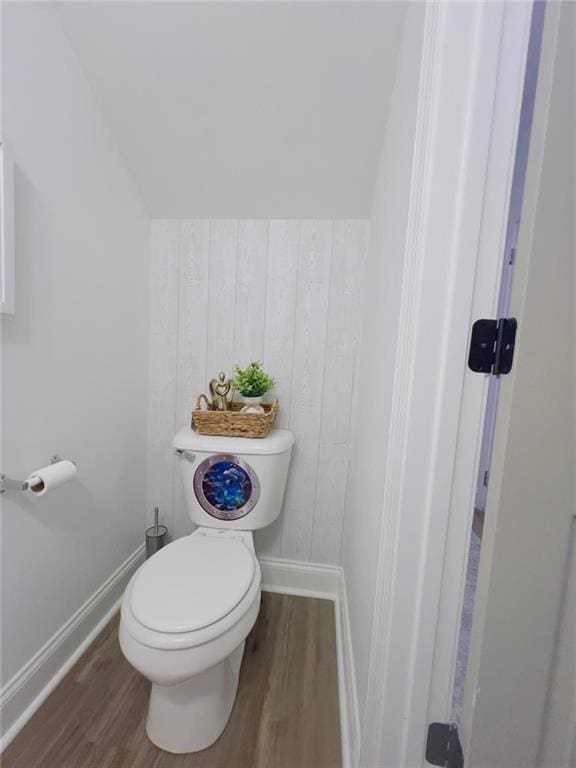 bathroom featuring toilet, vaulted ceiling, and wood-type flooring