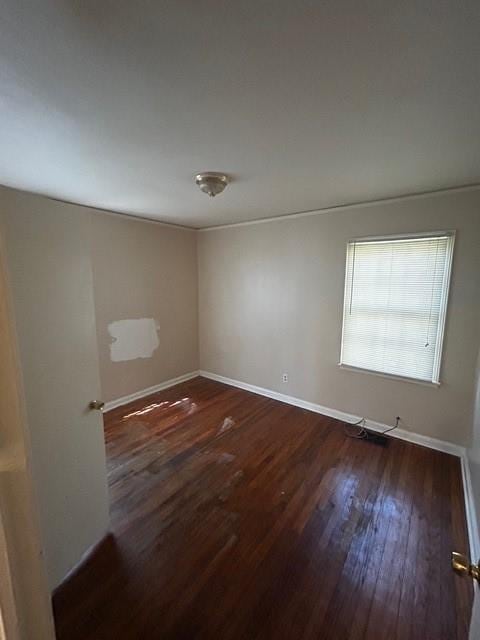 empty room with baseboards and wood finished floors