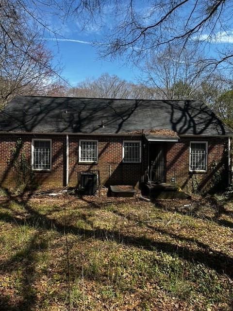 rear view of house featuring brick siding