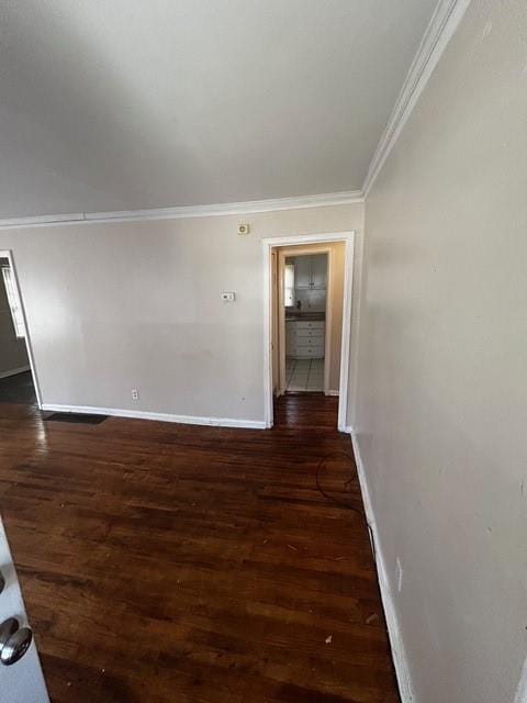 corridor with baseboards, wood finished floors, and crown molding