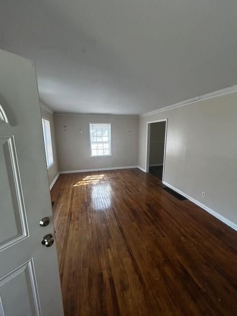 unfurnished room with ornamental molding, baseboards, and wood finished floors