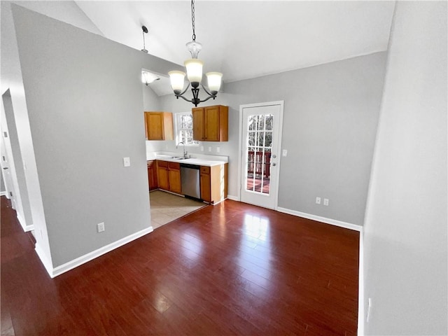 kitchen with pendant lighting, lofted ceiling, a notable chandelier, light hardwood / wood-style floors, and stainless steel dishwasher