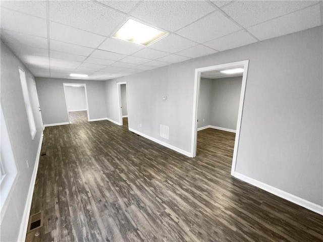 basement featuring dark hardwood / wood-style flooring and a drop ceiling