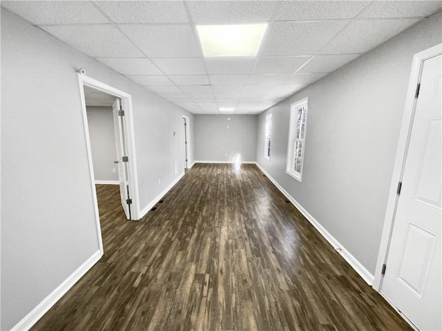 basement featuring dark hardwood / wood-style floors and a paneled ceiling