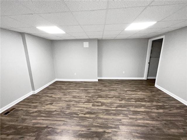 basement with a drop ceiling and dark hardwood / wood-style floors