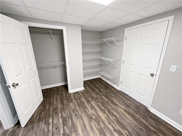 interior space with dark hardwood / wood-style floors and a drop ceiling