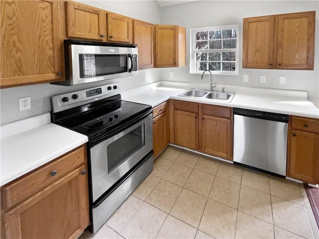 kitchen with stainless steel appliances, light tile patterned flooring, and sink