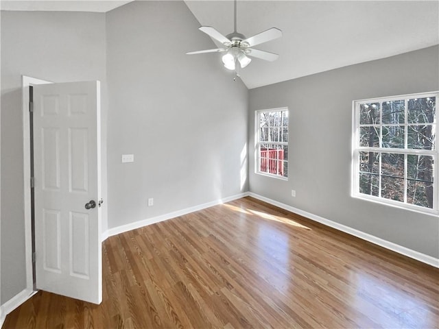 unfurnished room with hardwood / wood-style flooring, lofted ceiling, and ceiling fan