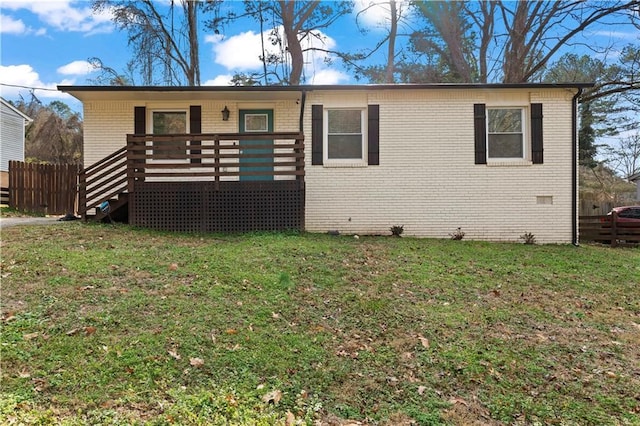 view of front of home with a wooden deck and a front lawn