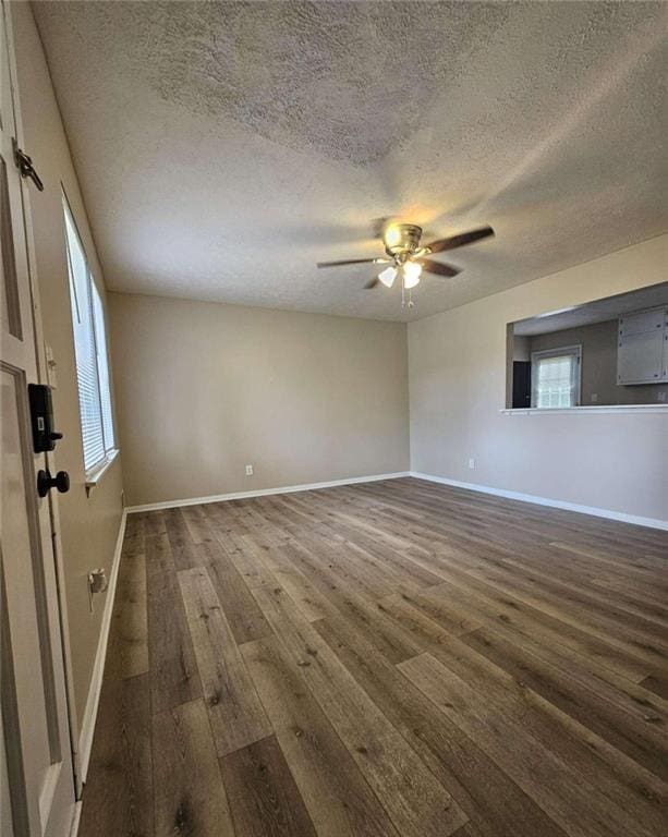 unfurnished room with dark wood-type flooring, a textured ceiling, and ceiling fan