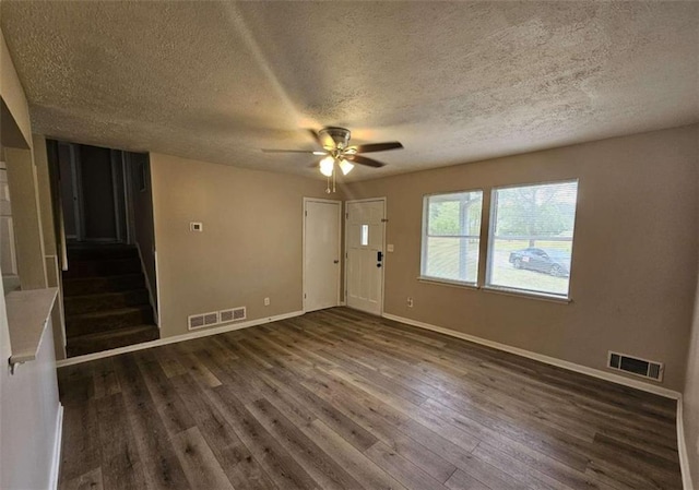 empty room with dark hardwood / wood-style flooring, ceiling fan, and a textured ceiling