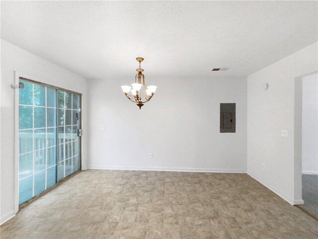 empty room with electric panel and a chandelier