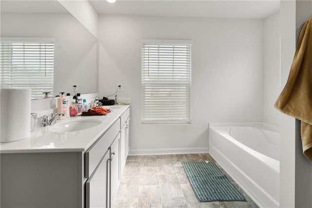 bathroom with a tub and vanity