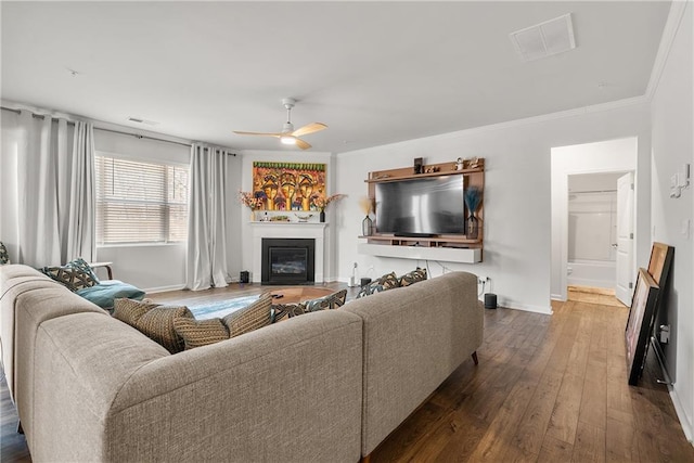 living room featuring ceiling fan, crown molding, and hardwood / wood-style flooring