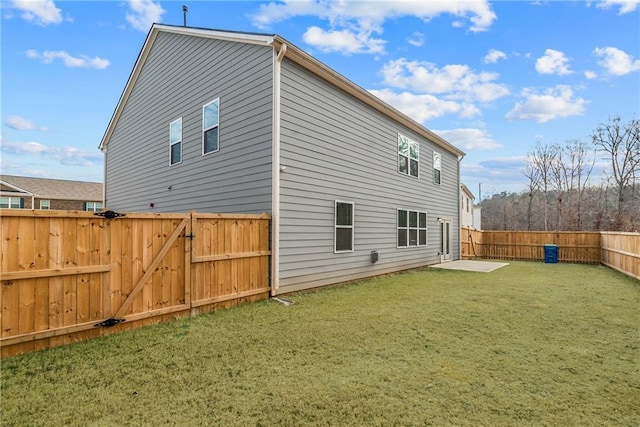 back of house featuring a patio area and a lawn