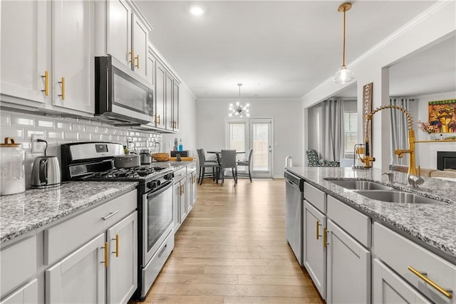 kitchen featuring decorative backsplash, sink, hanging light fixtures, and stainless steel appliances