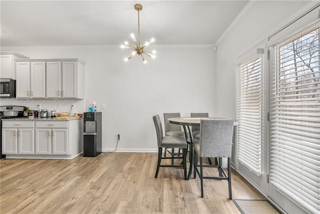 dining room featuring crown molding, a chandelier, and light wood-type flooring