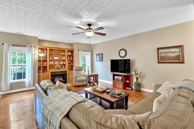 17 Sassafras Trl NE, Cartersville, GA 30121 - living room featuring ceiling fan, wood finished floors, a fireplace, and a textured ceiling