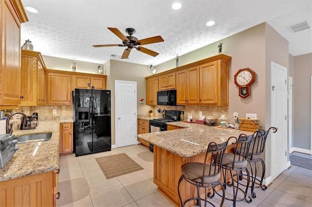 17 Sassafras Trl NE, Cartersville, GA 30121 - kitchen with black appliances, a peninsula, light stone countertops, a ceiling fan, and backsplash