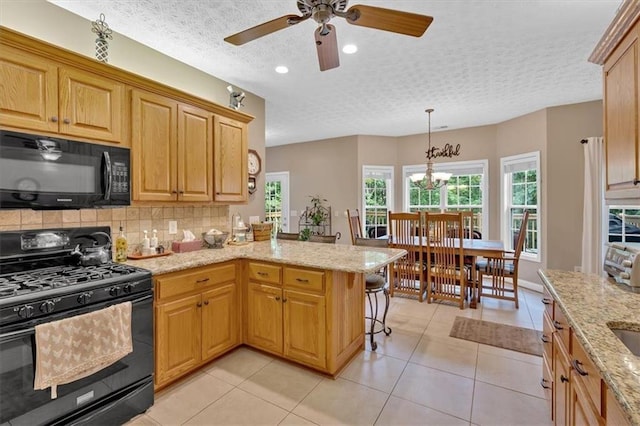 17 Sassafras Trl NE, Cartersville, GA 30121 - kitchen with black appliances, a peninsula, a ceiling fan, light stone counters, and a textured ceiling