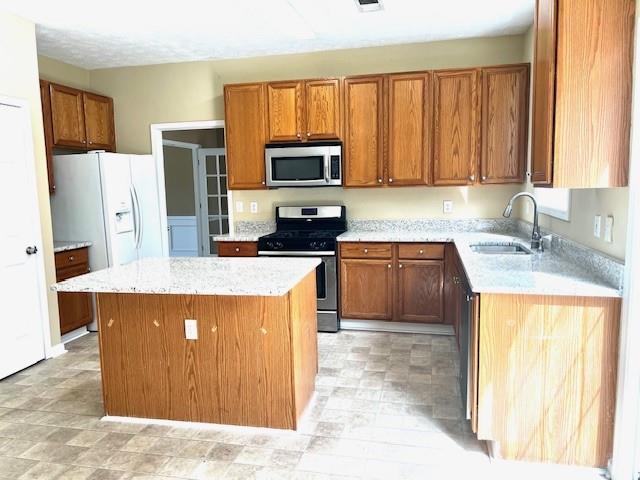 kitchen with a kitchen island, sink, and stainless steel appliances