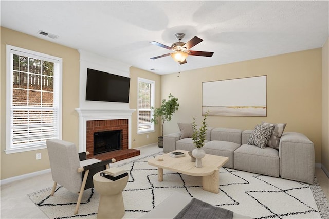 living room featuring ceiling fan, light carpet, and a brick fireplace