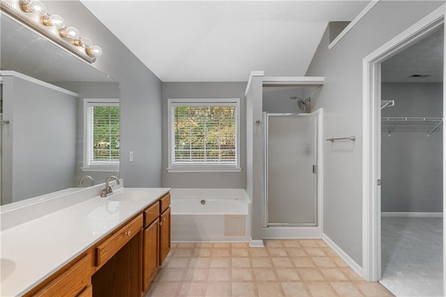 bathroom with shower with separate bathtub, vanity, and vaulted ceiling