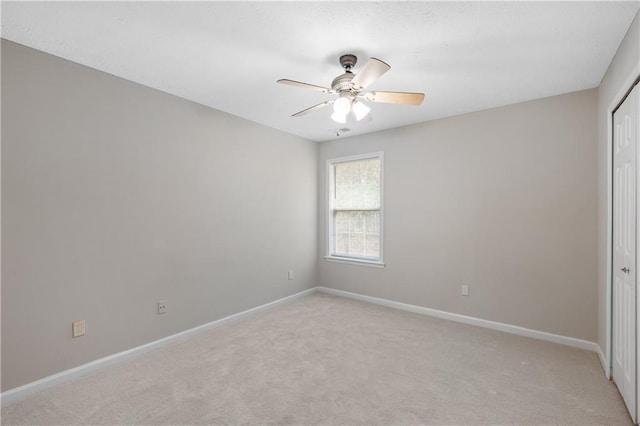 empty room featuring light colored carpet and ceiling fan