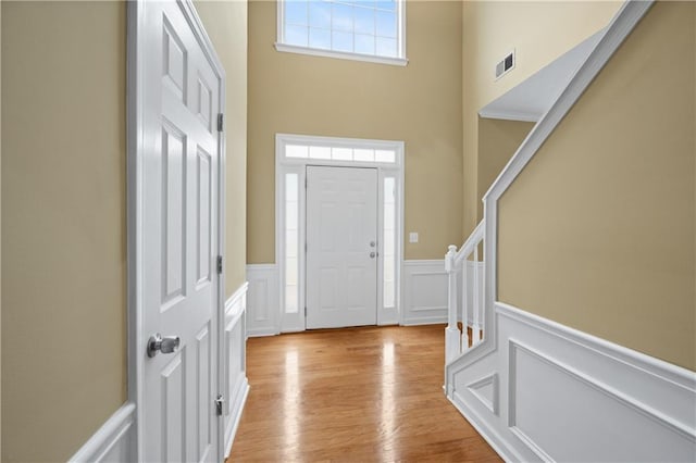 foyer entrance featuring a high ceiling and light wood-type flooring