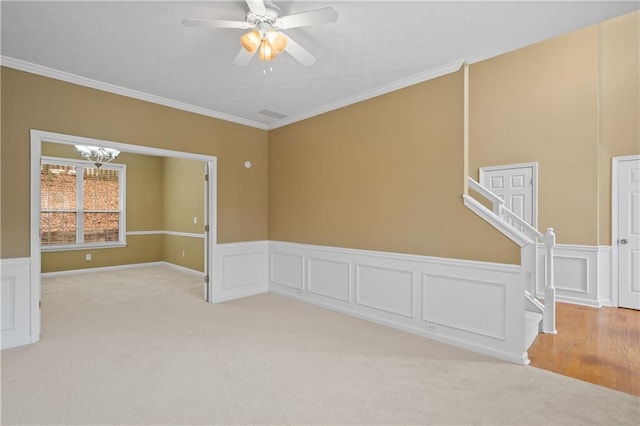 unfurnished room featuring light carpet, crown molding, and ceiling fan with notable chandelier