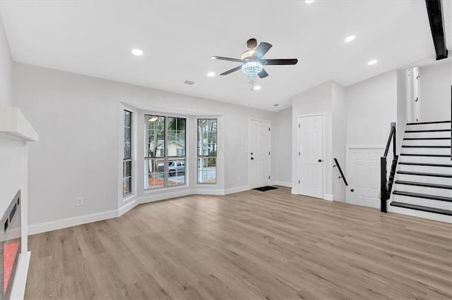 unfurnished living room featuring recessed lighting, light wood-style flooring, and baseboards