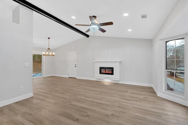 unfurnished living room with baseboards, light wood finished floors, lofted ceiling with beams, a glass covered fireplace, and ceiling fan with notable chandelier