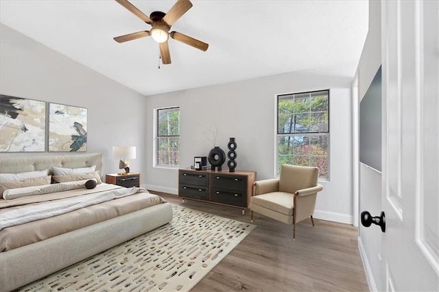 bedroom featuring ceiling fan, baseboards, lofted ceiling, and wood finished floors