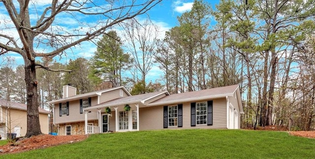 tri-level home with a chimney and a front lawn