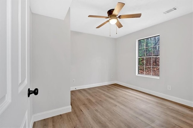 spare room with visible vents, baseboards, wood finished floors, and a ceiling fan