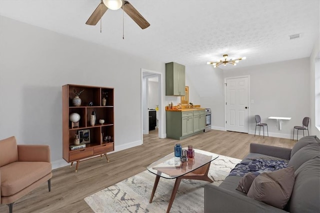 living area featuring baseboards, a textured ceiling, and light wood-style floors