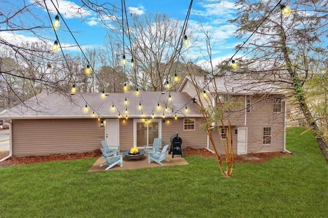 rear view of property featuring a yard, an outdoor fire pit, and a patio