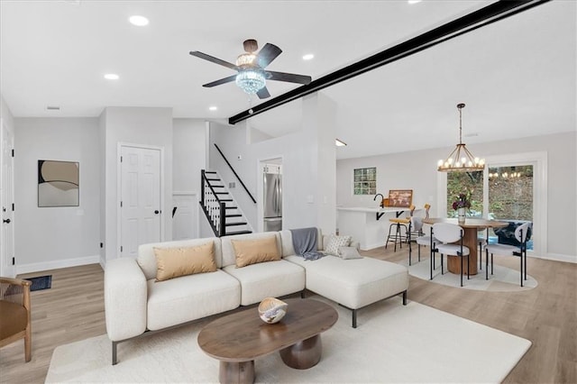 living room featuring light wood-type flooring, recessed lighting, stairway, baseboards, and vaulted ceiling