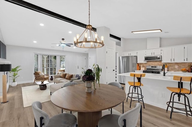 dining room featuring recessed lighting, baseboards, lofted ceiling, and light wood-style flooring