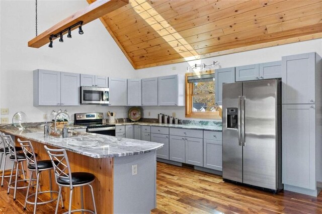 kitchen featuring kitchen peninsula, light stone countertops, wooden ceiling, light hardwood / wood-style flooring, and stainless steel appliances