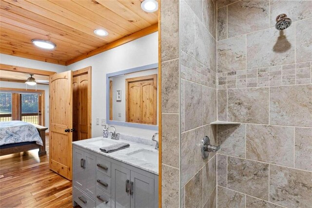 bathroom featuring vanity, wooden ceiling, tiled shower, and hardwood / wood-style floors