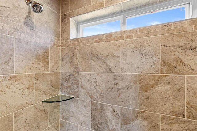 interior details featuring a tile shower