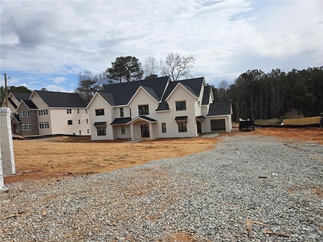 view of front of property featuring gravel driveway and a garage