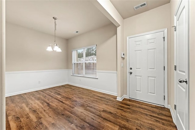 entrance foyer with dark hardwood / wood-style flooring and a notable chandelier