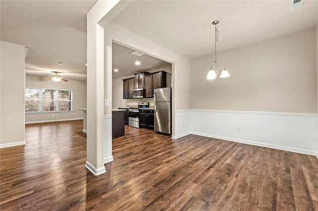 kitchen with pendant lighting, dark brown cabinets, stainless steel appliances, dark hardwood / wood-style flooring, and ceiling fan with notable chandelier